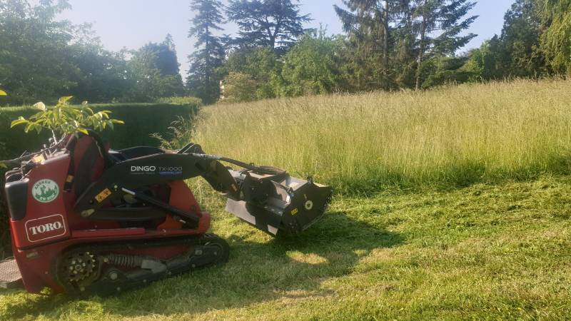 Débroussaillage d'un terrain à l'aide d'un gyrobroyeur